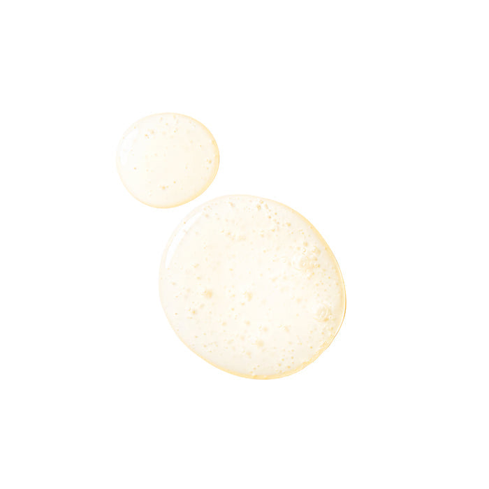 Two translucent, round liquid drops with tiny bubbles evoke the refreshing essence of Tree To Tubs Biotin & Caffeine Volumizing Shampoo for Sensitive Scalp. Set against a plain white background, they symbolize a gentle promise of volume and hair loss prevention.