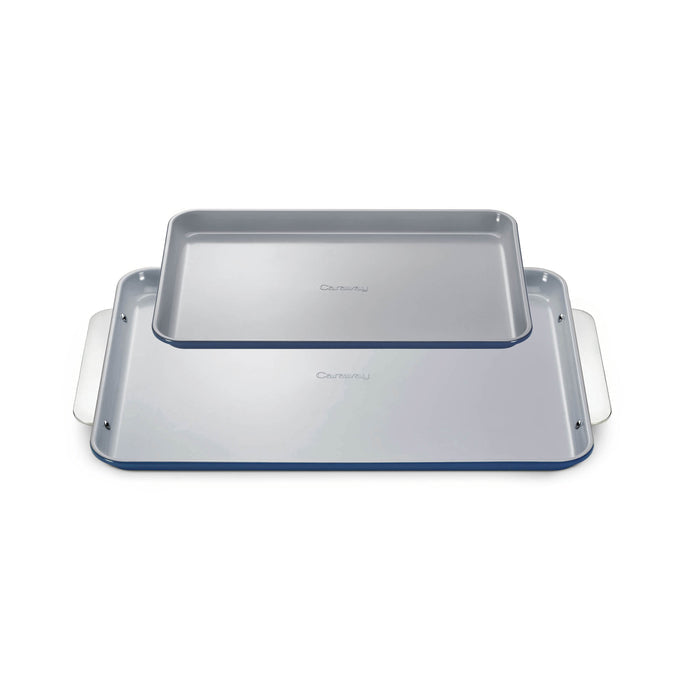The Caraway Ceramic Baking Sheet Duo includes two stacked light gray sheets with raised edges and integrated side handles. The naturally non-stick surfaces and subtle logo ensure non-toxic, healthy baking with ease and style.