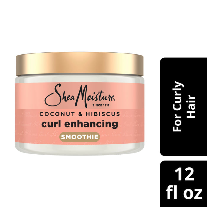 A jar of SheaMoisture Styling Aid Smoothie Curl Enhancing for curly hair, featuring a gold lid. The pink and white label highlights its anti-frizz formula, designed specifically for curly hair. Text alongside reads For Curly Hair, 12 fl oz.