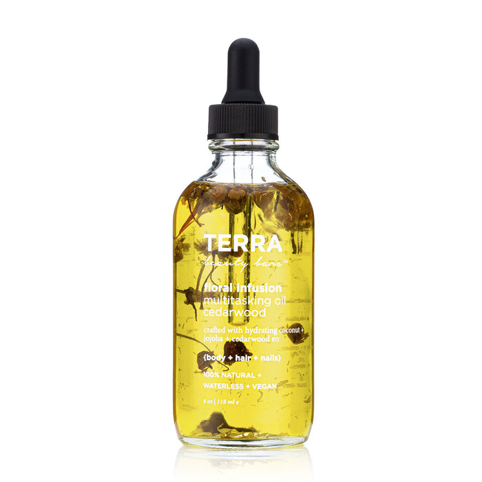 Terra Beauty Bars Floral Infusion Multitasking Oil for Body + Hair comes in a glass bottle with a dropper lid, featuring cedarwood and nourishing natural oils. It enhances self-care routines, nourishing body, hair, and nails while displaying dried florals within its golden hue.