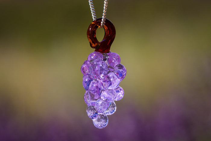 Glass grape cluster pendant infused with cremation ash, purple bead grapes hanging in a cluster on a silver chain.