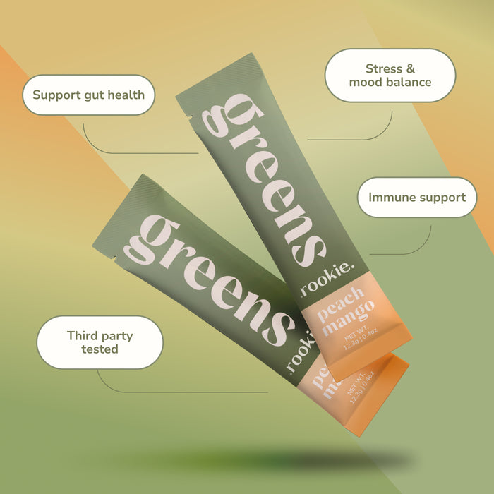 Two green and orange Rookie Wellness Greens + Superfood peach mango daily greens supplement stick packs are shown, with text bubbles highlighting “Support gut health,” “Stress & mood balance,” “Immune support,” and “Third party tested.”.