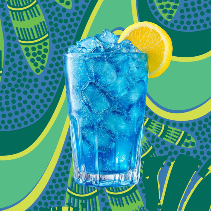 A clear glass of Marine Glow Organic Luminizing Blend by Kuli Kuli Foods, a blue iced drink with marine minerals and a lemon slice garnish, sits against a vibrant green and blue abstract background.