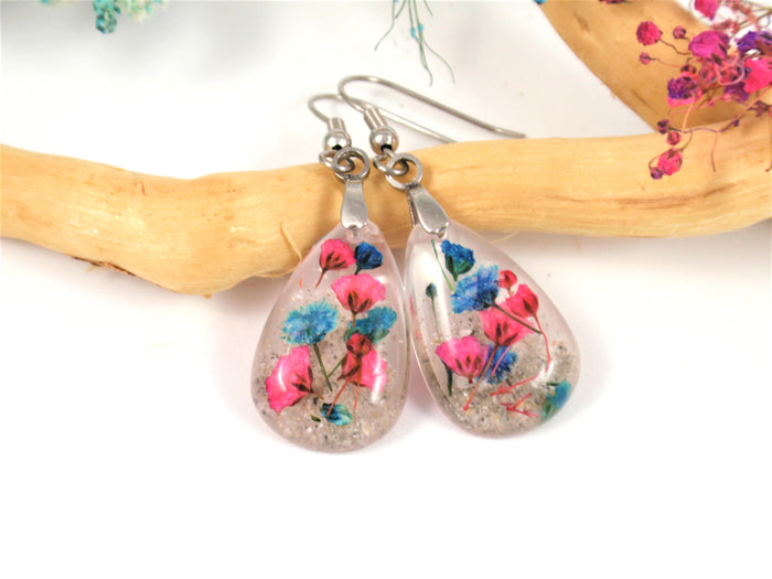 Teardrop crystal resin earrings featuring pink and blue baby's breath encased in cremains on surgical steel hooks