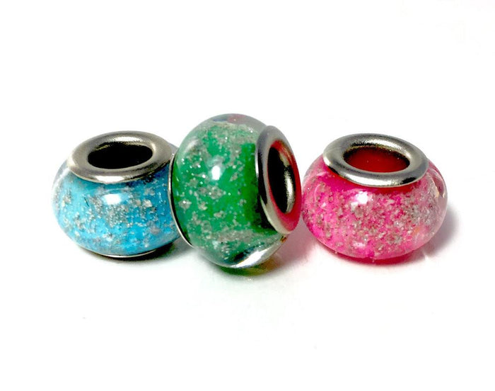 Three solid color cremains beads in blue, green, and pink with metal cores for Pandora style bracelets