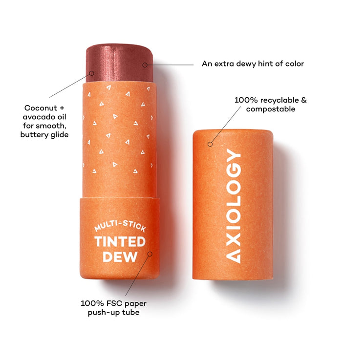 An open tube of Axiology Multi-Stick Tinted Dew is depicted. The tube is orange with a brown-tinted balm visible. Text highlights features like coconut and avocado oil, 100% recyclable and compostable packaging, 100% FSC paper push-up tube, and an extra dewy hint of color.