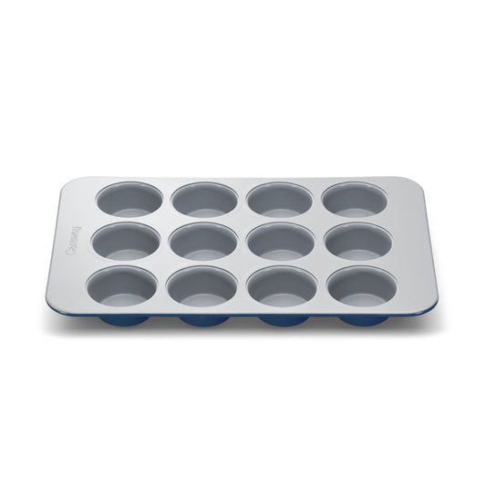 The Caraway Muffin Pan is a 12-cup metal baking tray with a safe gray non-stick surface and a blue silicone base.