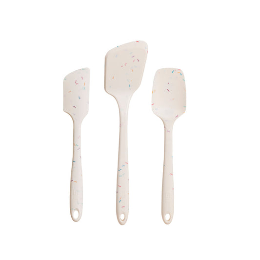Three white silicone spatulas with confetti specks, made from heat-resistant, pharmaceutical-grade silicone, are shown vertically against a white background. Each differs in size and shape and is part of the GIR 3-Piece Ultimate Tool Set for your kitchen needs.