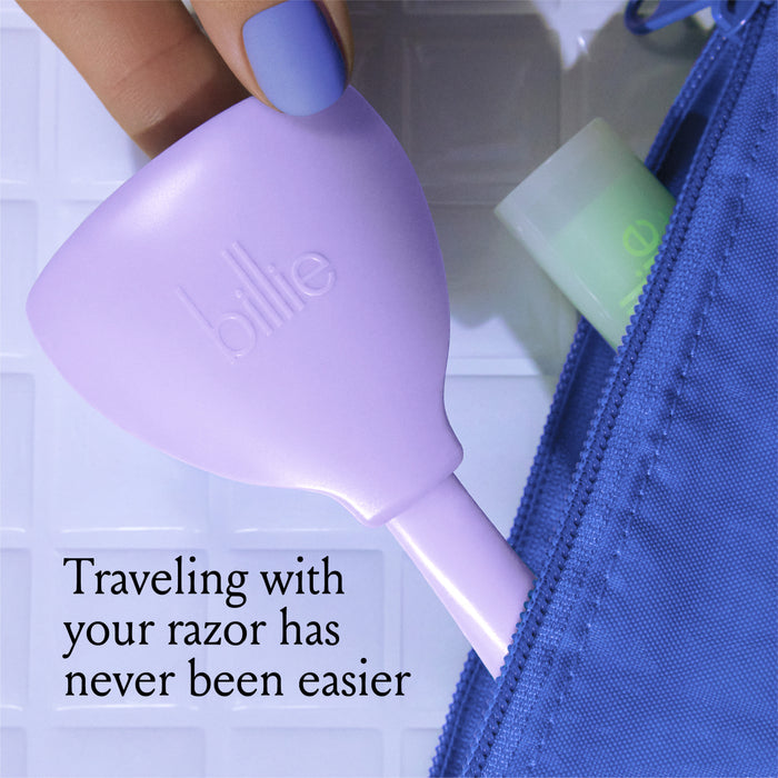 A purple razor case with the word "billie" is partially zipped into a blue bag. The text on the image reads, "Traveling with your razor has never been easier." A person with light blue nail polish holds the case.