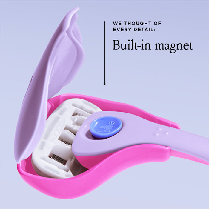Close-up of a pink and purple razor with an open cover, revealing multiple blades. A label reads, "We thought of every detail: Built-in magnet," with an arrow pointing to the handle. The background is light blue.
