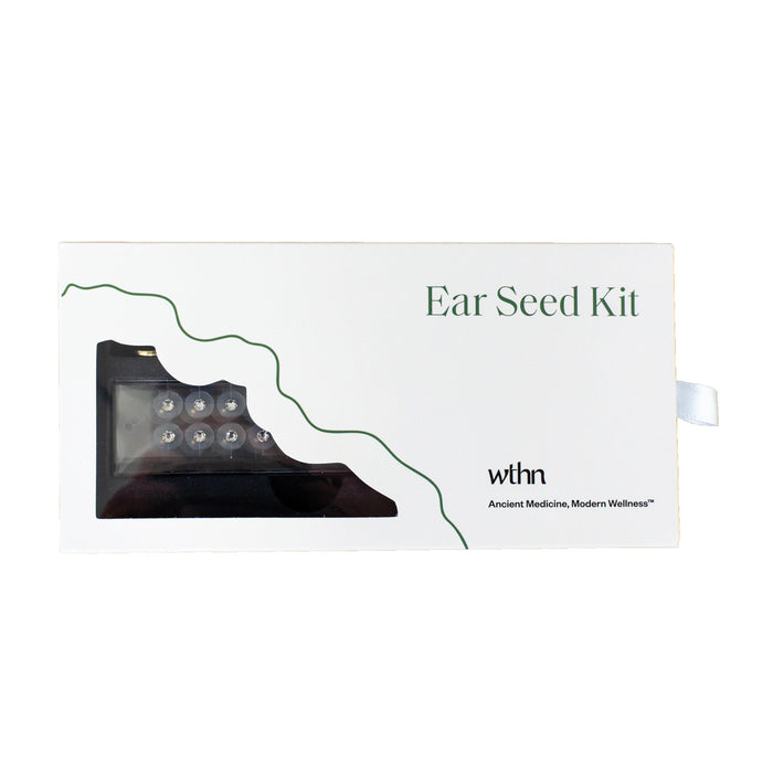 The image shows a white box labeled Acupressure Crystal Ear Seed Kit with ear seeds in a small cutout. Green decorative lines accentuate the design, showcasing the brand WTHN and the tagline Ancient Medicine, Modern Wellness, emphasizing acupressure and pain relief benefits.