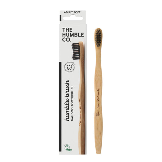 The Adult Bamboo Toothbrush - Soft from The Humble Co. features dentist-approved black nylon bristles and is elegantly presented in a white box with green and black text displaying the logo and the soft designation.
