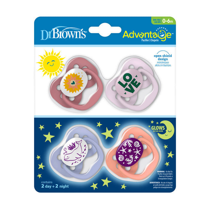 Dr. Browns Advantage Glow-in-the-Dark Baby Pacifier, Stage 1, features fully symmetrical soothers with soft silicone bulbs for ages 0-6 months. The pack includes four pacifiers: two with pink floral/sun designs and two glowing purple ones with LOVE text and a narwhal design.