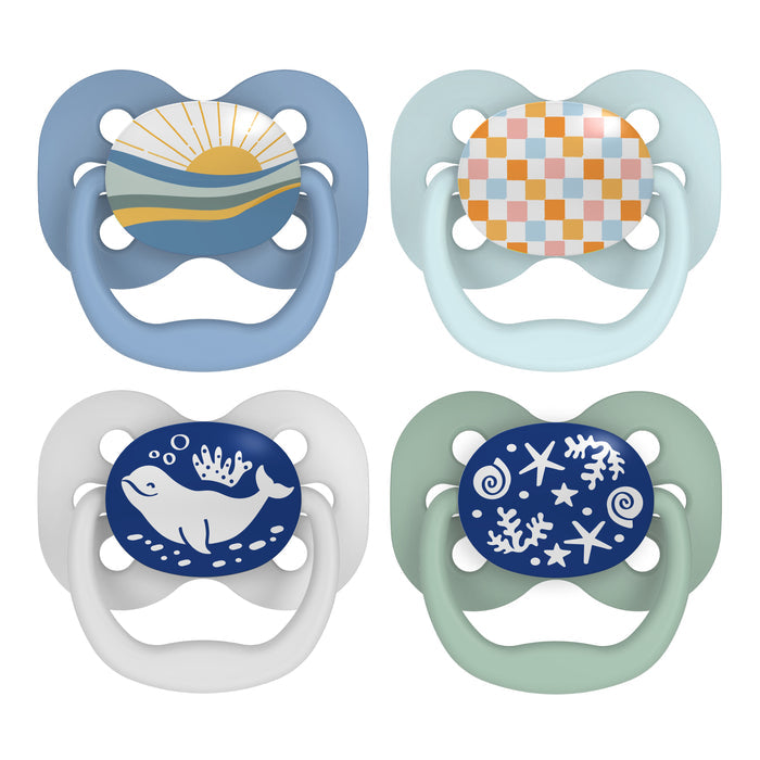 Dr. Browns Advantage Glow-in-the-Dark Baby Pacifiers, Stage 1, feature a BPA-free soft silicone bulb and display designs like a sun over waves, multicolored checks, a whale with bubbles, and stars with swirls in calming blue, white, and pastel tones.