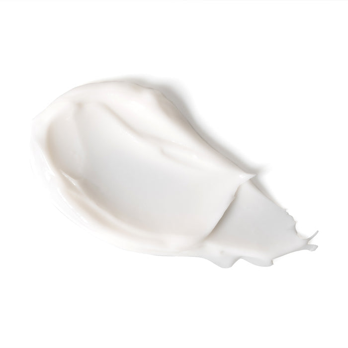 A close-up of the Age Defying Apricot Probiotic Cleansing Milk by Andalou Naturals shows its glossy, peaked texture. This facial cleanser for dry skin is enriched with age-defying antioxidants for radiant skin on a white background.