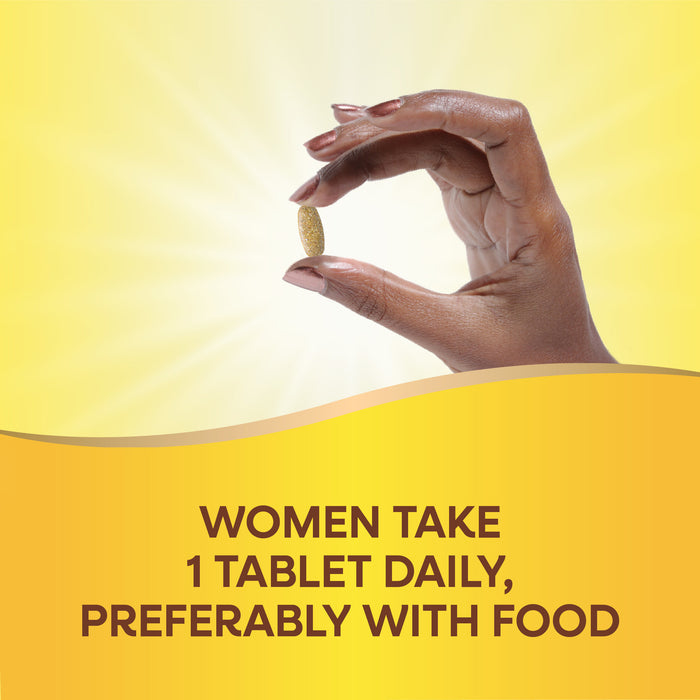 A hand holds a Nature’s Way Alive!® Once Daily Women 50+ Ultra tablet against a yellow background with sunlight, above text: Women take 1 tablet daily, preferably with food.