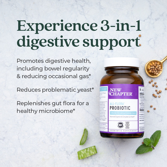 A bottle of New Chapter All-Flora™ Probiotic for Advanced Digestion & Complete Gut Health sits on a light surface with herbs and seeds. Text highlights 3-in-1 digestive support, promotes regularity, reduces gas, and restores gut flora.