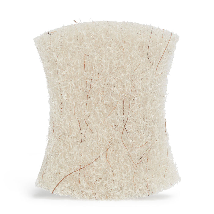 A close-up image of Grove Co.s Coconut Scouring Pads reveals their intricate, textured design. The beigeish-white loofah-like texture with visible fibrous strands mimics a natural loofah sponge, highlighting its rough yet non-abrasive surface against a plain white background.