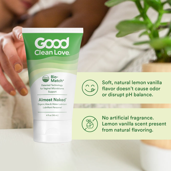 Close-up of a tube labeled "Good Clean Love Almost Naked," featuring its moisturizing, natural lemon vanilla flavor and pH balance support. Water-based for natural lubrication, a hand holds the tube near a green plant with informational text visible beside the product.