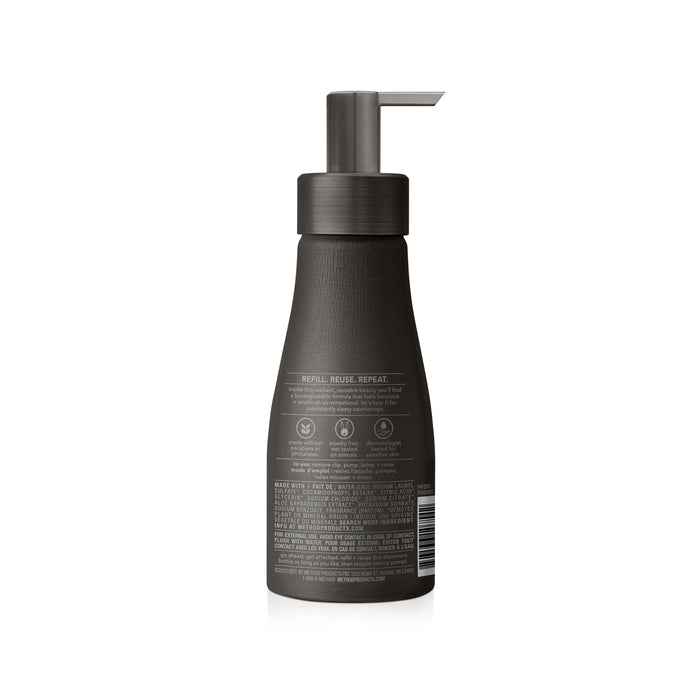 The method Aluminum Foaming Hand Soap comes in a dark brown matte pump bottle with a sensitive skin-friendly formula. Its label features a recycling symbol and reuse instructions, highlighting sustainability with refillable bottles. Detailed product info and a barcode are on the back.