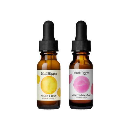 The Mad Hippie AM PM Dual Pack shows two brown dropper bottles; the left has a yellow circle for Vitamin C Serum with antioxidants, and the right features a pink circle for AHA Exfoliating Peel. Both have elegant black caps.