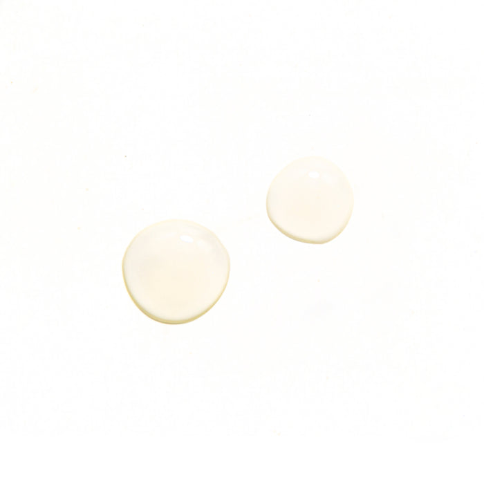 Two small, round puddles of a clear liquid on a white background with soft shadows capture the essence of Tree To Tubs Anti-Aging Peptide & Niacinamide Serum For Face, evoking subtle elegance and the refined power of transformation.