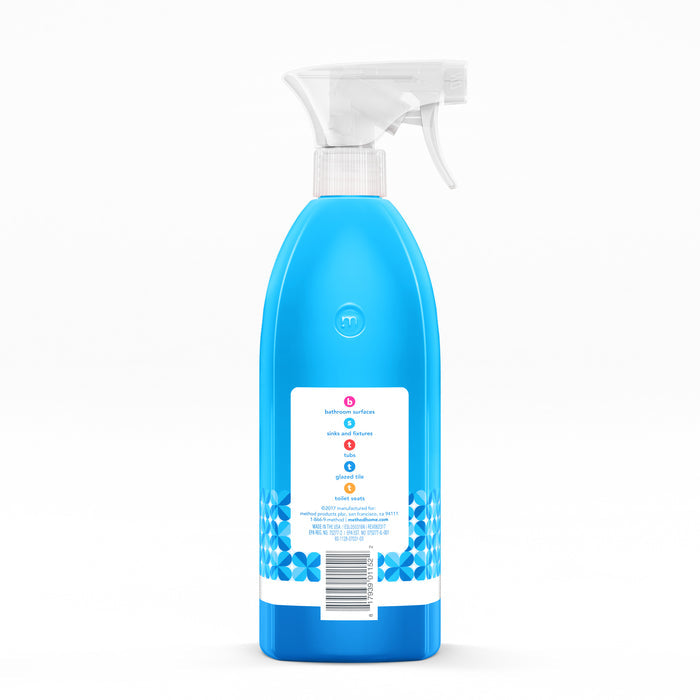 A blue spray bottle with a white trigger nozzle contains methods Antibacterial Bathroom Cleaner. The label features blue flowers, multilingual instructions emphasizing germ-fighting effectiveness, and has a barcode at the bottom center.