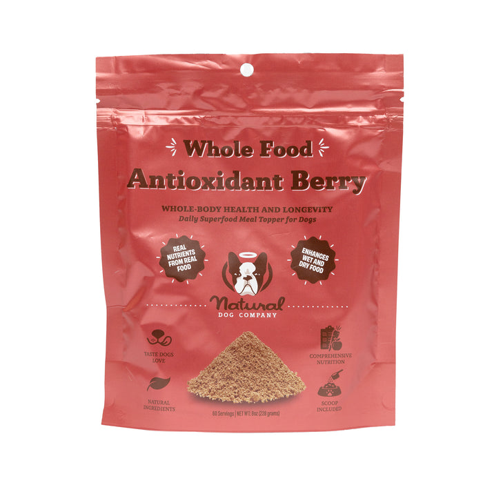 The Antioxidant Berry Superfood Granules by Natural Dog Company come in a red package and are a nutrient-rich meal topper for dogs, promoting health and longevity. They support the immune system with natural ingredients and include a scoop inside.