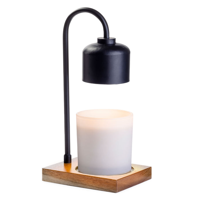 Introducing the Arched Candle Warmer Lamp by Candle Warmers Etc., a modern masterpiece featuring a sleek black metal arc and chic cylindrical metallic shade. It hovers over a glowing white candle on a stylish wood base, blending simplicity and functionality perfectly.