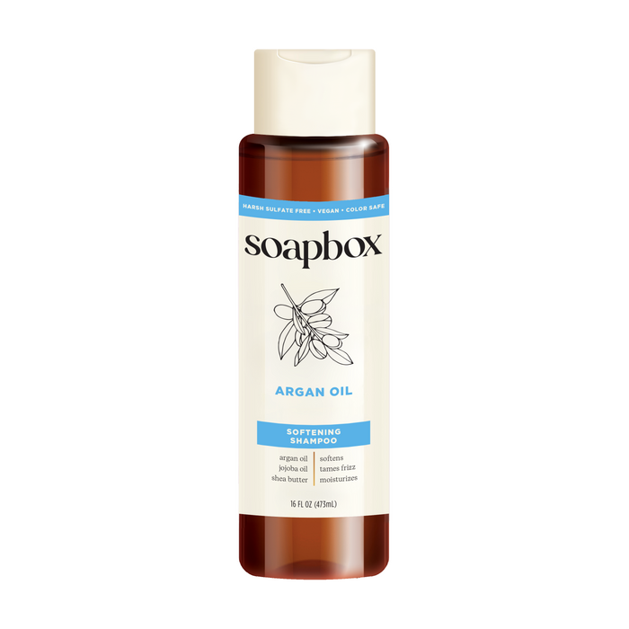 Soapbox Argan Oil Softening Shampoo, 16 fl oz, is enriched with a vitamin complex and key ingredients like argan oil, shea butter, and jojoba oil. It is sulfate-free, vegan, color-safe, has a brown bottle with a white cap.