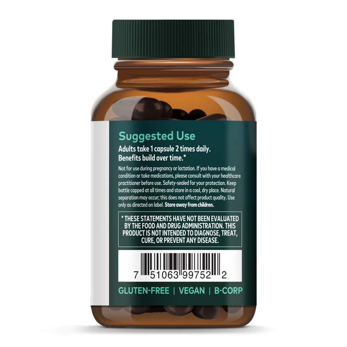 A brown Gaia Herbs Ashwagandha Root bottle with a green cap displays a label featuring suggested use, disclaimer, barcode, gluten-free, vegan, and B-Corp icons. The bottle contains dark Ashwagandha Root capsules.