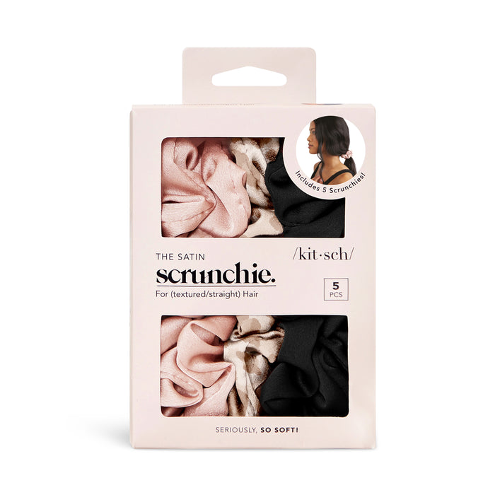 Kitschs Assorted Satin Sleep Scrunchies set includes five scrunchies in pink, black, and leopard print. Packaged in a white box designed to prevent frizz and breakage, it features product details and an image of a woman wearing a scrunchie.