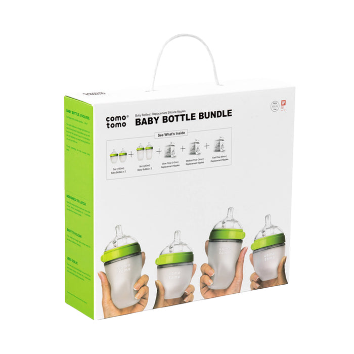 A white and green Baby Bottle Gift Set box from Comotomo displays images of anti-colic baby bottles with green lids, designed for easy breastfeeding transition, and various nipple flow options above the four included bottles.