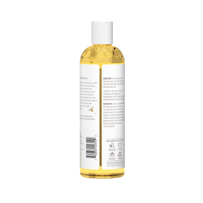 A clear bottle containing soothing yellow liquid with text and symbols sits against a plain white backdrop. Its white cap seals the gentle essence of Burts Bees Baby Shampoo & Wash Calming.