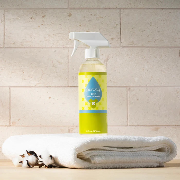 A bottle of Baby Stain Remover on a white towel, with cotton stems beside it.