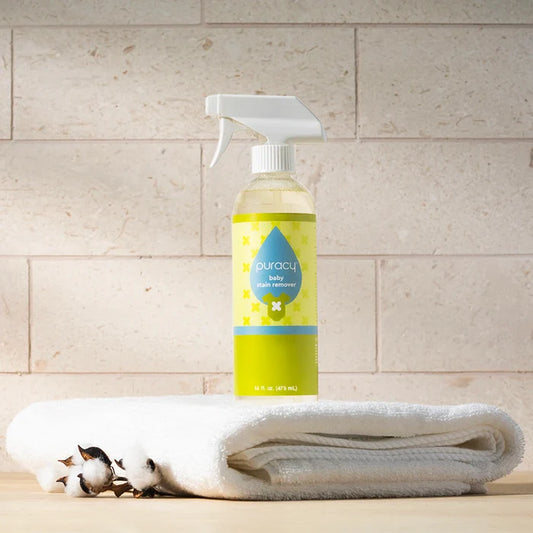 A bottle of Baby Stain Remover on a white towel, with cotton stems beside it.