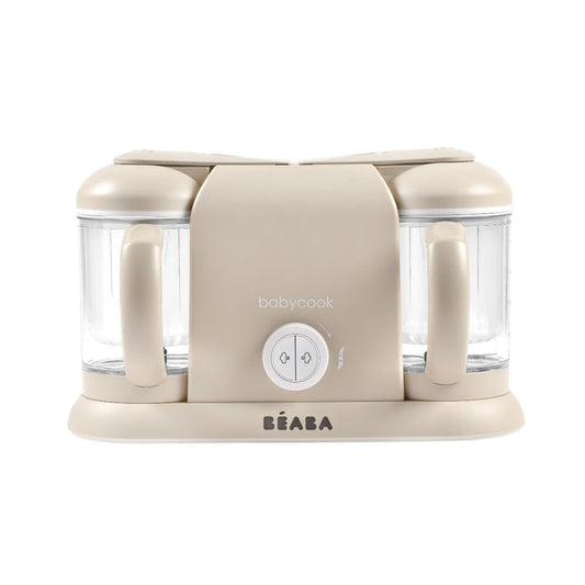 The BEABA Babycook Duo baby food maker in beige has dual transparent containers, handles for one-handed use, and a front-facing round control knob with babycook above. The brand name BEABA is elegantly displayed at the base—ideal for effortlessly making homemade baby food.
