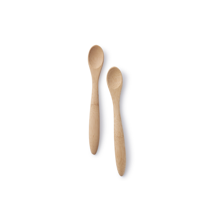 Two Bambu Babys Feeding Spoons (6M+) with rounded handles, crafted from all-natural materials and featuring a smooth, polished finish, are placed on a white background. They are positioned parallel to each other with slight spacing in between.