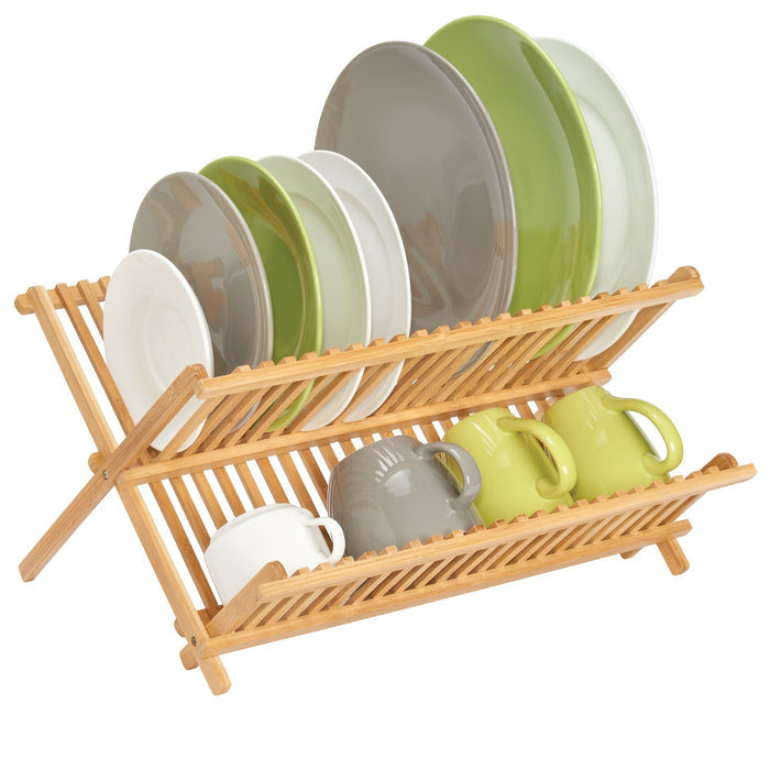 The iDesign Bamboo Folding Collapsible Dish Drying Rack elegantly holds various colored plates on the top tier and coordinating mugs below. Its collapsible design features shades of gray, green, and white in both dishes and mugs while emphasizing the natural beauty of renewable bamboo.