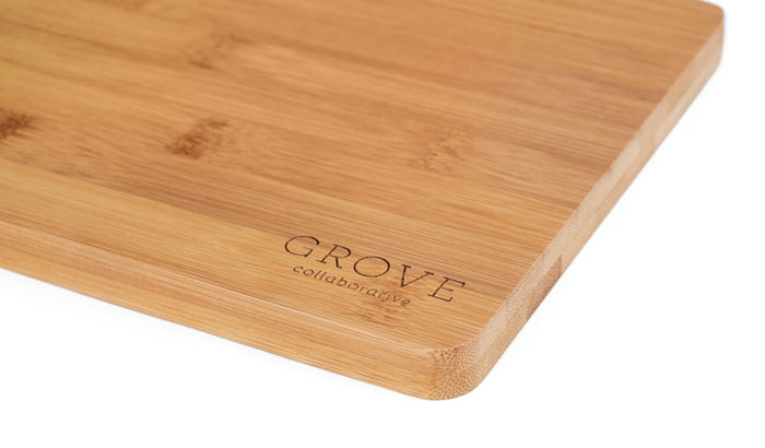 The Grove Co. Bamboo Prep Board features a close-up view with Grove Co. engraved in one corner. This eco-friendly board offers a smooth texture and rounded edges, providing natural antibacterial properties for safe food preparation.