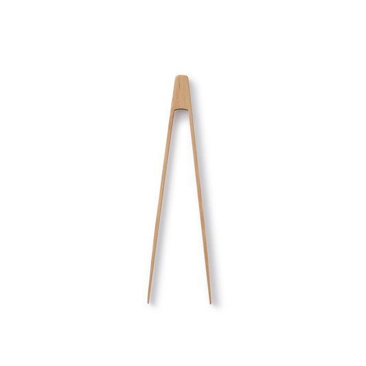 A single set of Bambus Small Tongs made from organic bamboo features a smooth, natural finish and slightly tapered ends against a plain white background, epitomizing simple elegance.