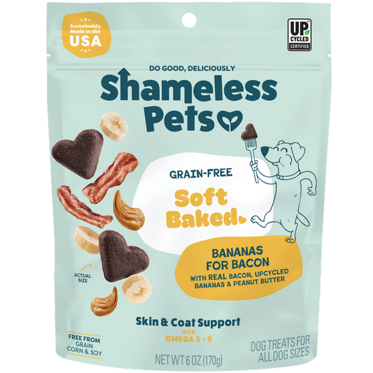 Shameless Pets Bananas for Bacon Soft-Baked Dog Treats are grain-free, heart-shaped snacks made in the USA with upcycled ingredients like bacon, cashews, and bananas to support skin and coat health—featuring a fun cartoon dog on the package!.