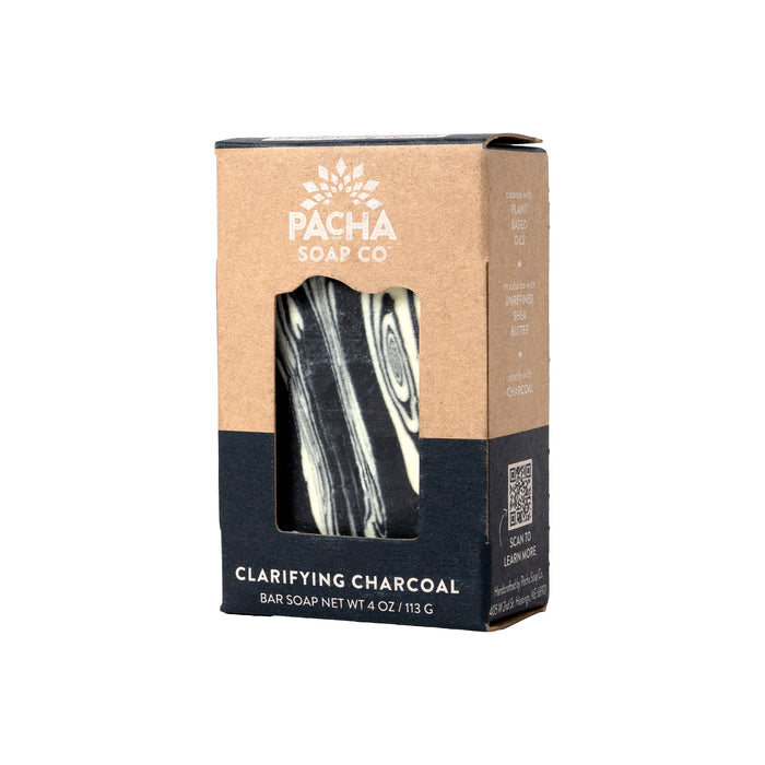 A brown and black marbled bar soap in cardboard packaging features a window highlighting the Clarifying Charcoal. The package displays the text Pacha Soap Co and Clarifying Charcoal Bar Soap Net Wt 4 oz / 113g, with a QR code visible on the side.