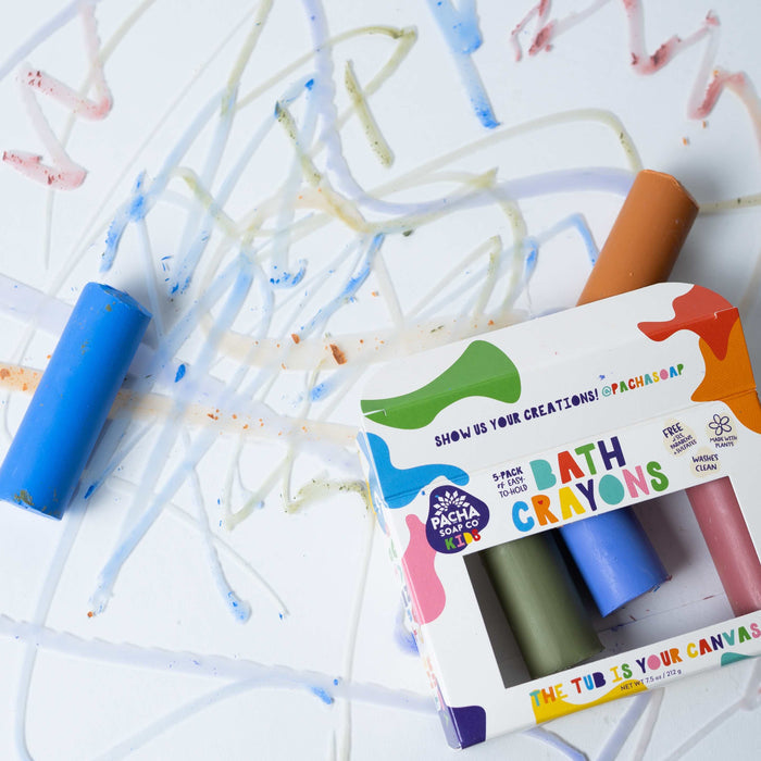 An open box of Pacha Soap Co. Bath Crayons lies on a white surface, surrounded by vibrant scribbles created with non-toxic, natural colorants.