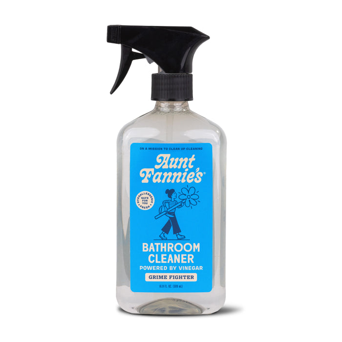 Aunt Fannies Bathroom Cleaner spray has a black nozzle and a blue and white label with someone holding a flower. It features Vinegar Powered and Grime Fighter. Enhanced with plant-based surfactants, its an eco-friendly way to achieve sparkling clean surfaces.