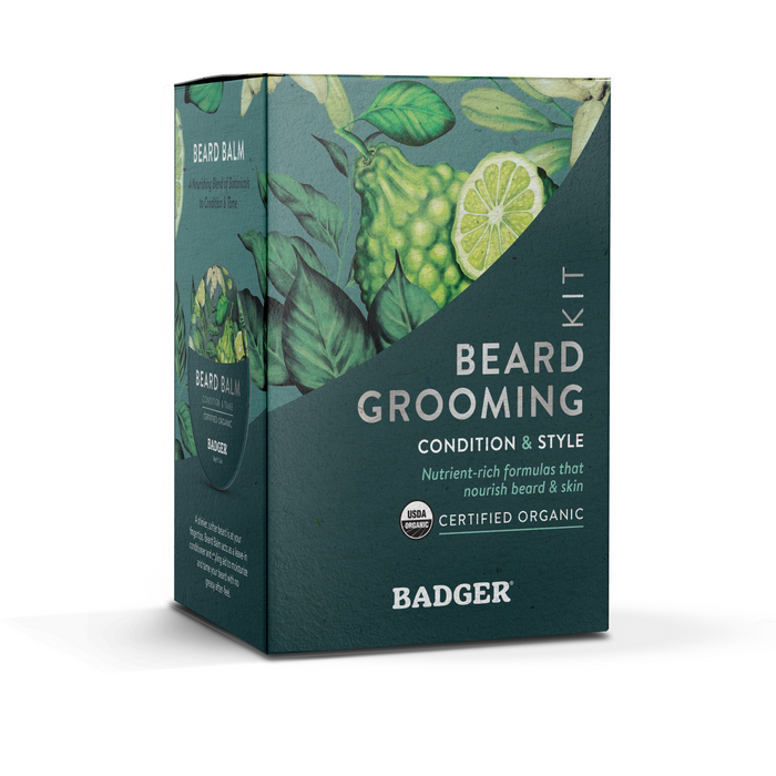 The Beard Grooming Kit by Badger Balm features packaging with green leaves and a hint of lime. Labels emphasize its organic nature for conditioning and styling facial hair, and the USDA Organic certification is prominently displayed, assuring quality for all beard enthusiasts.
