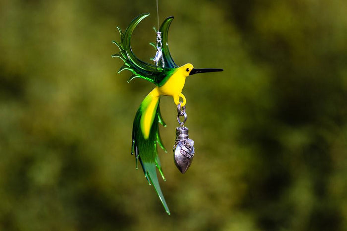 Vibrant green and yellow glass bee eater pendant with a dangling silver keepsake urn for ashes.