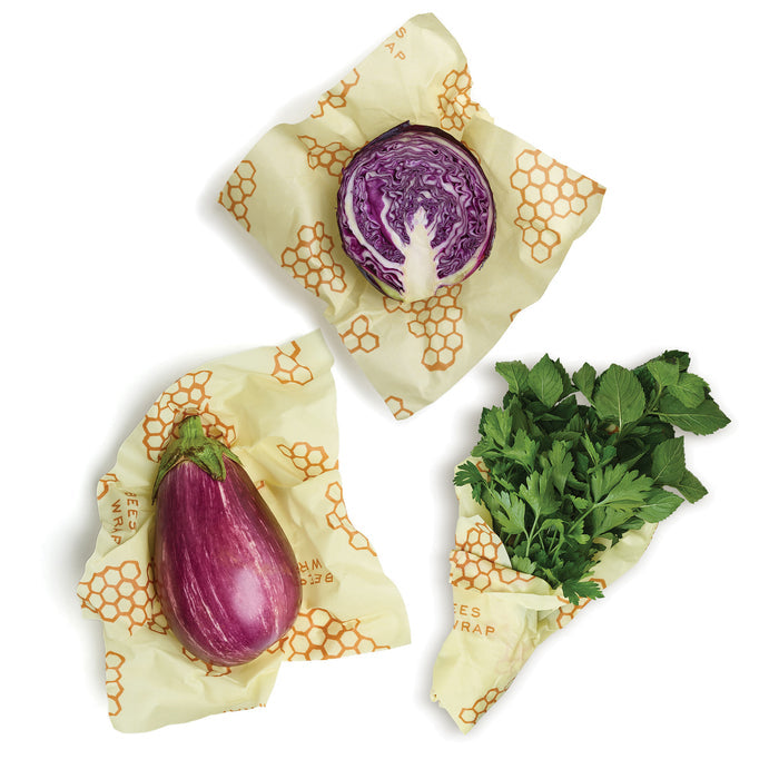 A halved purple cabbage, a striped eggplant, and parsley are wrapped in Bee's Wrap Beeswax Wraps for Food - Large, an eco-friendly food storage and plastic wrap alternative with a honeycomb pattern on a white background.