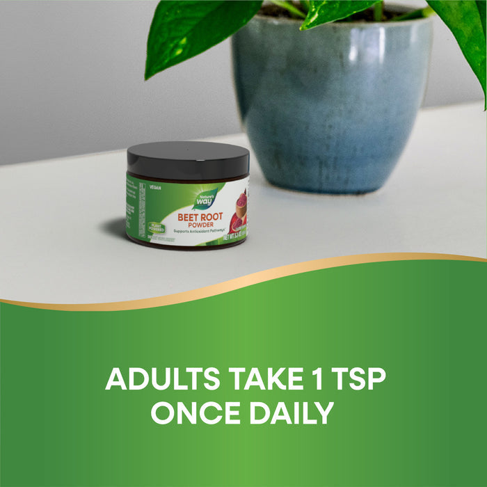 A container of Natures Way Beet Root Powder sits on a white surface next to a green potted plant. Rich in phytonutrients, it supports antioxidant pathways. Text below reads: ADULTS TAKE 1 TSP ONCE DAILY on a green background.