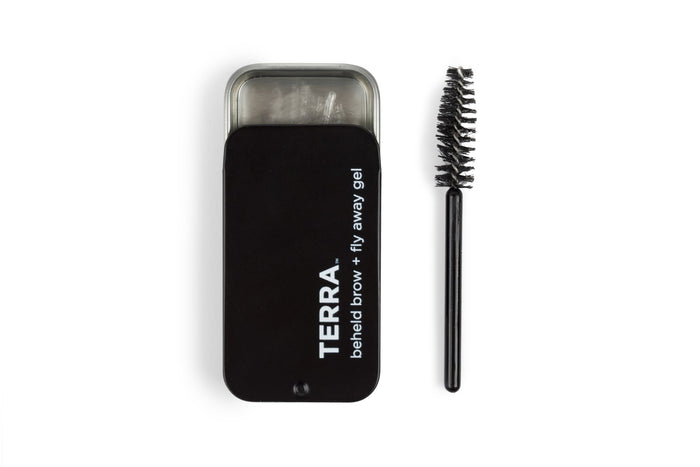 A black rectangular tin with a TERRA Beheld Eye Brow Kit label is shown next to Beheld Brow + Fly Away Gel and a spoolie brush on a white background.